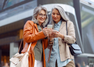two older women looking at a mobile