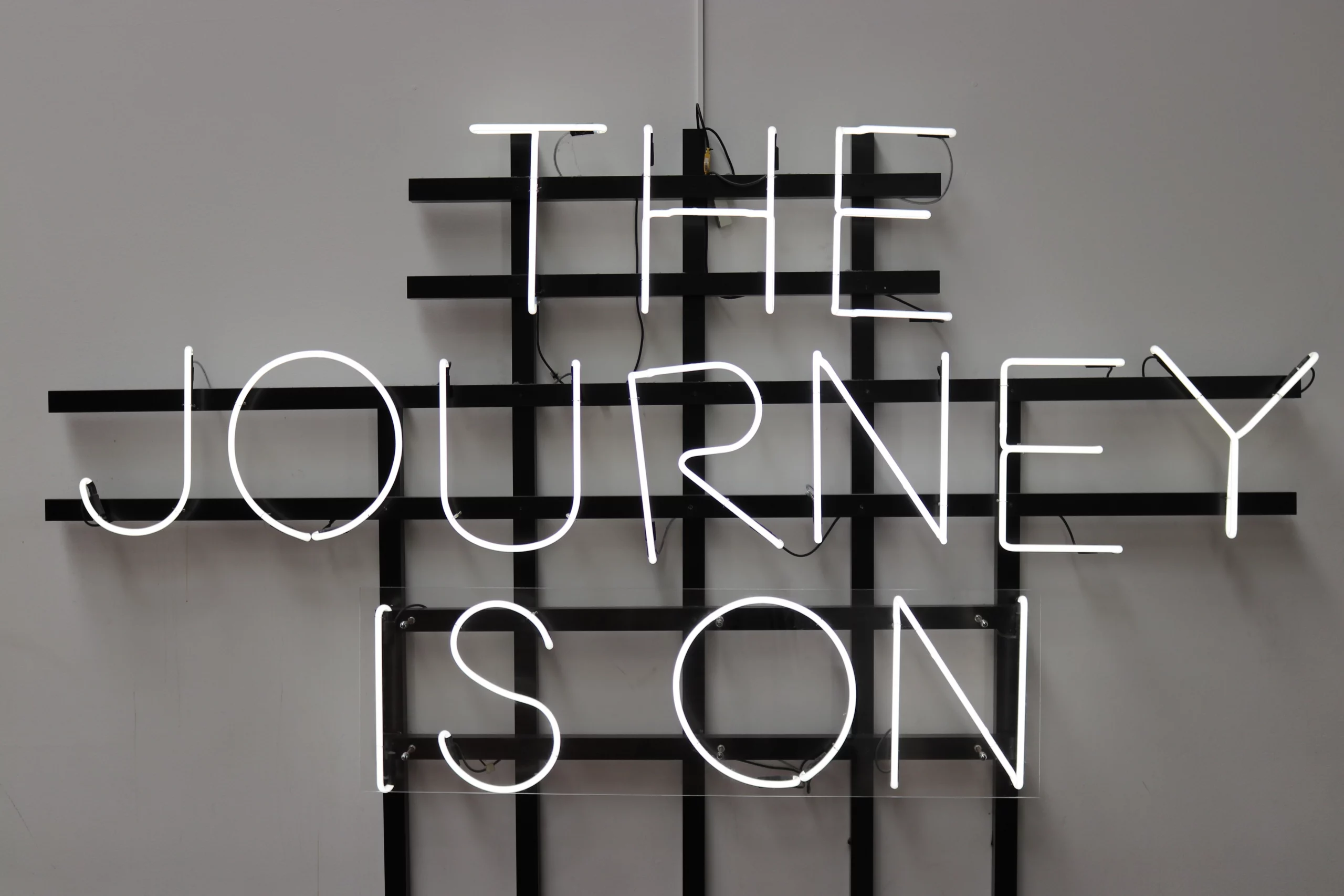 neon sign that says the journey is on
