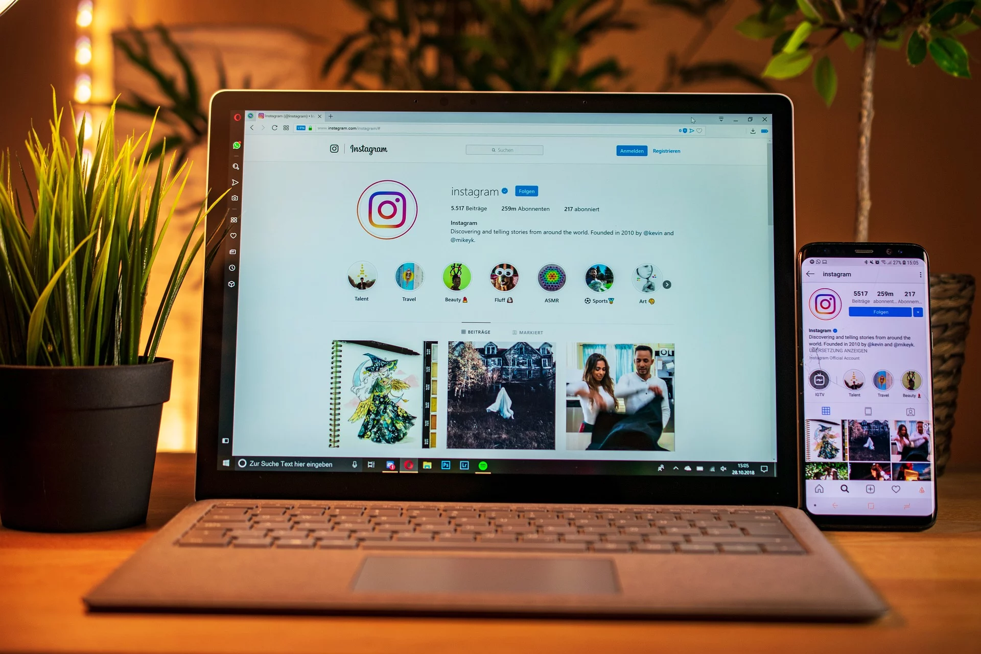 instagram displayed on a laptop and mobile on wooden desk