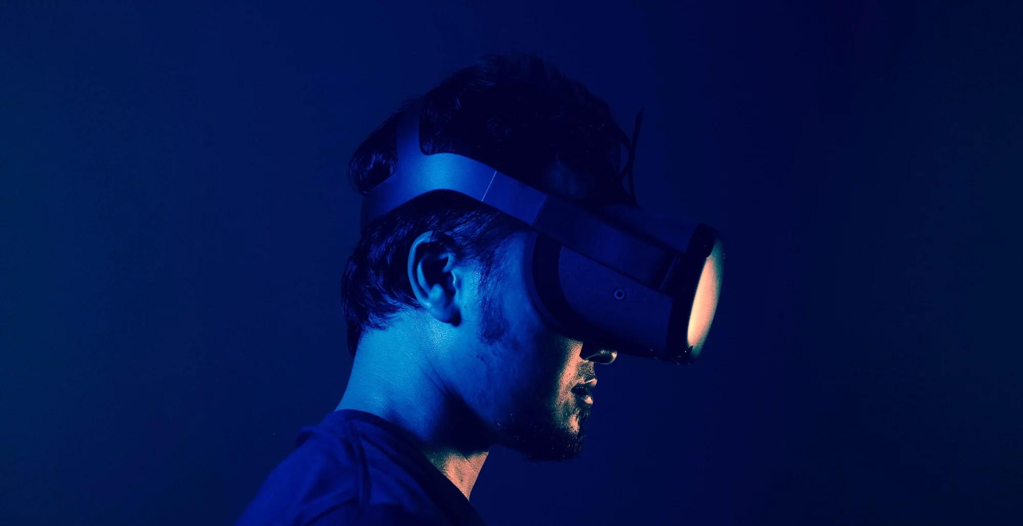Male wearing VR headset in a blue light setting