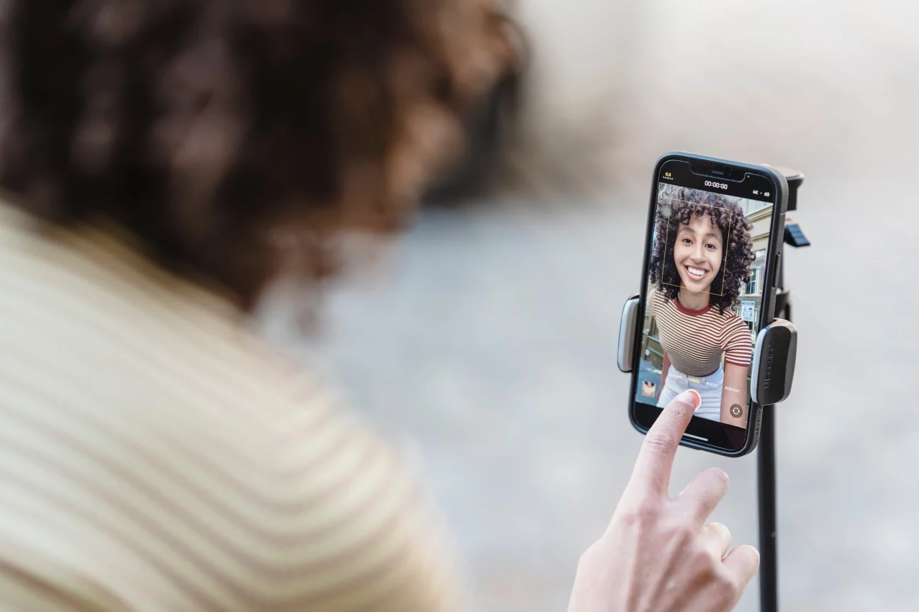 woman recording self with selfie camera on phone