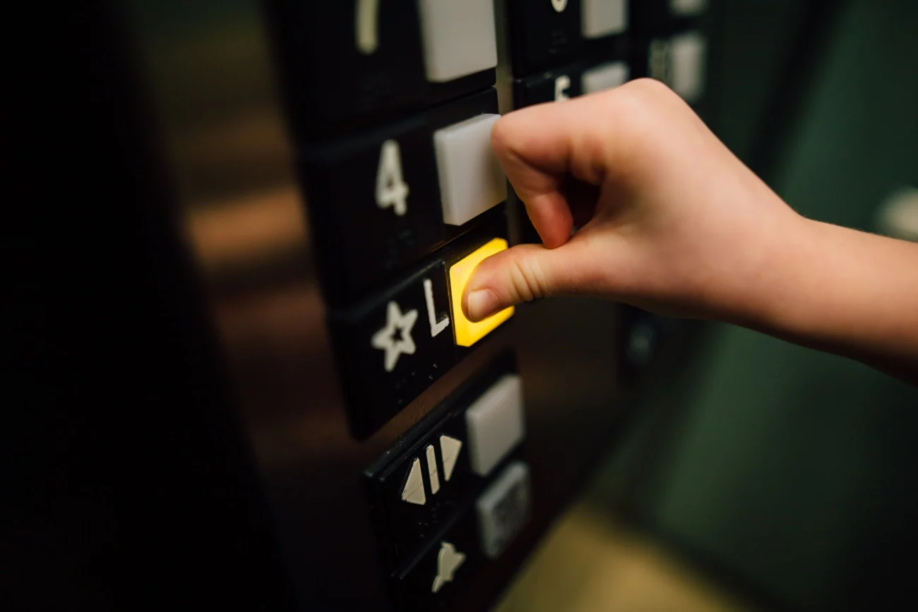 hands pressing yellow lift button